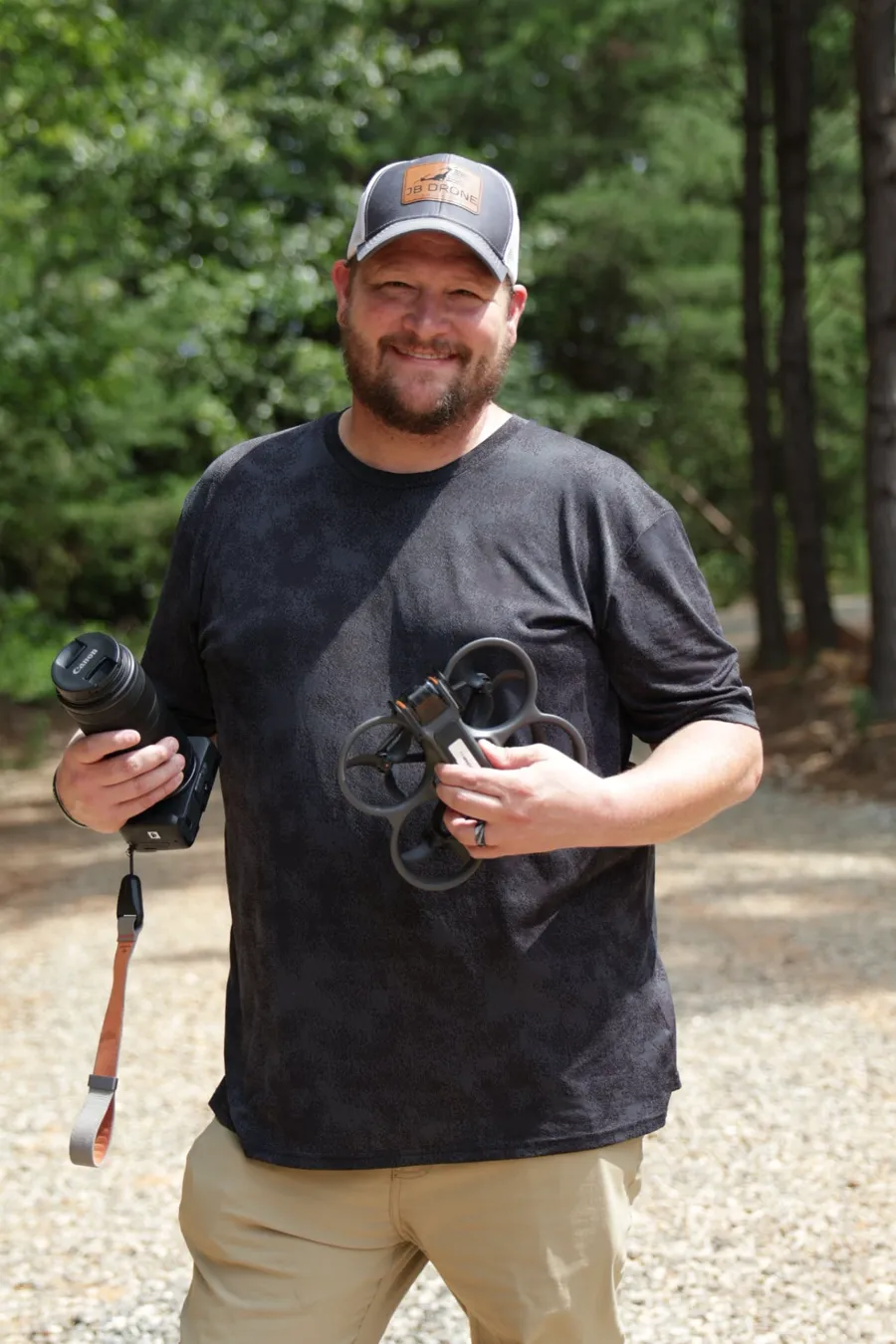 Jimmy, founder of JB Drone Solutions, holding a Canon camera and a drone on location in North Carolina